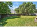 Large, grassy backyard enclosed by a wood fence, perfect for outdoor activities at 3808 Hopper St, Raleigh, NC 27616
