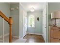 Bright entryway featuring hardwood floors, a staircase, and an arched window for natural light at 404 Cary Pines Dr, Cary, NC 27513