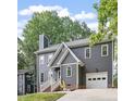 Charming two-story home featuring a gray exterior, brick foundation, and attached one-car garage at 404 Cary Pines Dr, Cary, NC 27513