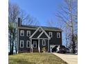 Charming two-story home with gray exterior, brick foundation, one-car garage, and a driveway with two cars at 404 Cary Pines Dr, Cary, NC 27513