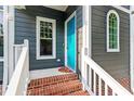 Inviting front porch with brick steps, white railings, and a bright blue door showcasing curb appeal at 404 Cary Pines Dr, Cary, NC 27513