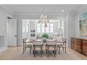 Elegant dining room with hardwood floors, modern lighting, and seamless flow into the bright kitchen at 411 Flat Rail Trl, Cary, NC 27511