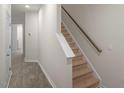 Inviting entryway featuring hardwood floors leading to a carpeted staircase at 412 Ember St, Sanford, NC 27330