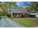Quaint brick home with flowering tree and brick walkway to covered porch at 418 S 2Nd St, Smithfield, NC 27577