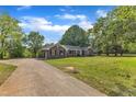 Wide driveway leading up to brick home with verdant front lawn and lush trees at 4314 Hopkins Rd, Middlesex, NC 27557