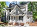 View of the home's exterior showcasing its gray siding, white trim, and well-kept landscaping at 4621 Worthington Ln, Raleigh, NC 27604