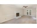 Living room with neutral walls, fireplace, carpet, and french doors to the back at 4621 Worthington Ln, Raleigh, NC 27604