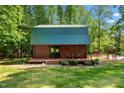 Log cabin style guest house features a green metal roof, lovely deck, and peaceful wooded surroundings at 515 Tramway West Rd, Sanford, NC 27330