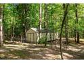 An outdoor storage shed with neutral siding, providing practical storage solutions in a woodsy setting at 515 Tramway West Rd, Sanford, NC 27330