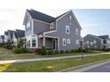 Lovely home showcasing stone accents, gray siding, well-maintained lawn, and walkway to the front door at 5200 Beckom St, Raleigh, NC 27616
