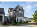 Beautiful two-story house featuring gray siding, stone accents, and professionally landscaped yard with colorful flowers at 5200 Beckom St, Raleigh, NC 27616