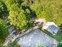 Aerial view of a property featuring a barn, riding arena, surrounded by lush greenery and mature trees at 54 Malcolm Neal Path, Louisburg, NC 27549