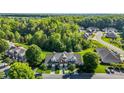 Aerial view of townhomes surrounded by lush trees and landscaping at 604 Oakfield Trl, Mebane, NC 27302
