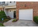 Inviting front entrance of townhome with well-maintained landscaping and attached garage at 604 Oakfield Trl, Mebane, NC 27302