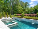 Stunning pool area features a jacuzzi and meticulous landscaping for a luxurious retreat at 6208 Old Miravalle Ct, Raleigh, NC 27614