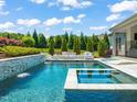 Backyard pool with jacuzzi, waterfall, and seating area is ideal for entertaining at 6208 Old Miravalle Ct, Raleigh, NC 27614