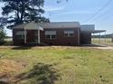 Quaint brick home featuring window awnings and a covered carport area at 6555 Nc 58, Nashville, NC 27856