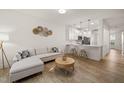 Open-concept living area with modern decor, hardwood floors, and breakfast bar at 7611 Satinwing Ln, Raleigh, NC 27617