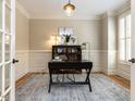 Cozy office with a stylish desk, hardwood floors, wainscoting, and ample natural light at 800 Skymont Dr, Holly Springs, NC 27540