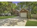 Traditional brick home featuring a two-car garage, established trees, and a well-manicured lawn at 900 Finchurch Cir, Wake Forest, NC 27587