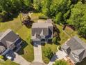An aerial view of the home with manicured lawn, mature trees, adjacent homes, and a playground at 9701 Precious Stone Dr, Wake Forest, NC 27587