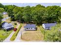 Aerial view of a cozy home with a dark roof, surrounded by lush trees and other charming neighborhood homes at 1013 Graham St, Burlington, NC 27217