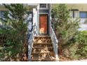 Charming entrance with wood stairs leading to a glass front door framed by lush greenery at 102 Martins Point Pl, Cary, NC 27519