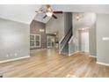 Spacious living room features wood flooring, stairs, stylish chandeliers, and sliding doors at 102 Martins Point Pl, Cary, NC 27519