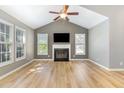 Bright living room boasts a fireplace, wood floors, vaulted ceilings, and natural light from large windows at 102 Martins Point Pl, Cary, NC 27519