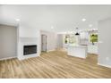 Spacious living room and kitchen featuring an electric fireplace and modern flooring at 109 Riverbend Dr, Archer Lodge, NC 27527