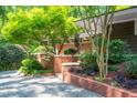 Close up of the front entrance with brick lined walkway and lush landscaping at 1111 Sourwood Cir, Chapel Hill, NC 27517