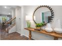 Inviting entryway with wood floors, console table, decorative mirror, and staircase at 1200 Pavo Path, Wendell, NC 27591