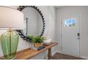 Bright entryway showcases a wooden console table adorned with a lamp, vases, and decorative plants, leading to a door at 1212 Pavo Path, Wendell, NC 27591