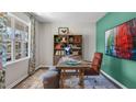 Cozy office space with large window, wooden desk, comfortable chair, and a colorful rug for a creative atmosphere at 1212 Pavo Path, Wendell, NC 27591