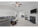 Bright living room featuring a fireplace, ceiling fan, and neutral carpet at 124 Willa Chase Ct, Benson, NC 27504