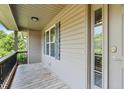 Covered porch with wood flooring, black railing, and space for outdoor seating at 124 Willa Chase Ct, Benson, NC 27504
