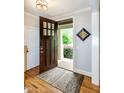 Inviting entryway features a dark wood door with glass panes, hardwood floors and neutral walls at 1820 Yates Wheel Way, Raleigh, NC 27606