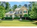 Charming two-story home featuring a well-manicured lawn, professional landscaping, and mature shade trees at 1820 Yates Wheel Way, Raleigh, NC 27606