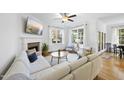 Bright living room with fireplace, hardwood floors, ceiling fan, and comfortable white seating at 20 Paddy Ln, Youngsville, NC 27596