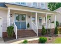 Charming exterior with blue front door, brick steps, and a welcoming porch with a swing at 2013 Waterton Ln, Apex, NC 27502