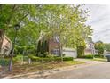 Charming two-story brick home with a two-car garage, lush trees, and manicured shrubs at 216 Beringer Pl, Chapel Hill, NC 27516