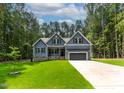 Charming blue home with a two car garage and a well manicured green lawn at 249 Rawhide Dr, Louisburg, NC 27549