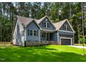 Charming home with blue siding, black shutters, brick foundation and well-manicured green lawn at 249 Rawhide Dr, Louisburg, NC 27549