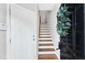 Inviting entryway with wood stairs, white walls, black door, and hardwood floors at 2705 Wyntercrest Ln, Durham, NC 27713