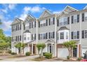 A row of townhomes featuring light gray siding and black shutters with attached garages at 2705 Wyntercrest Ln, Durham, NC 27713