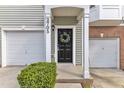Charming front entrance with black door, decorative wreath, manicured bushes, and attached two-car garage at 2705 Wyntercrest Ln, Durham, NC 27713