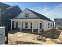 Angle of a white new construction home, brick facade and a charming front porch with classic white columns at 2874 Quarry Rd # 165, Rolesville, NC 27571