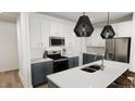 Modern kitchen with white and gray cabinets, stainless steel appliances, and center island at 2911 Alyssa Ct, Raleigh, NC 27604