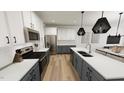 Modern kitchen with stainless steel appliances, white cabinets, and a spacious island with a sink at 2915 Alyssa Ct, Raleigh, NC 27604