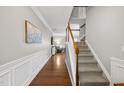 Inviting hallway with hardwood floors and carpeted stairs, leading to the upper level of the home at 322 Brier Crossings Loop, Durham, NC 27703